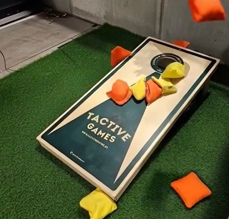 Corn Hole-spel från Tactive Games, med säckar i luften